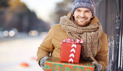 A man wearing a hat holds Christmas gifts while considering options like FUT and micropigmentation
